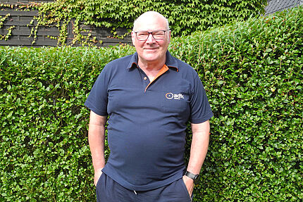Das Bild zeigt den ersten Vorsitzenden Jörg Kappmeyer im dunkelblauen ADFC-Poloshirt vor grüner Hecke