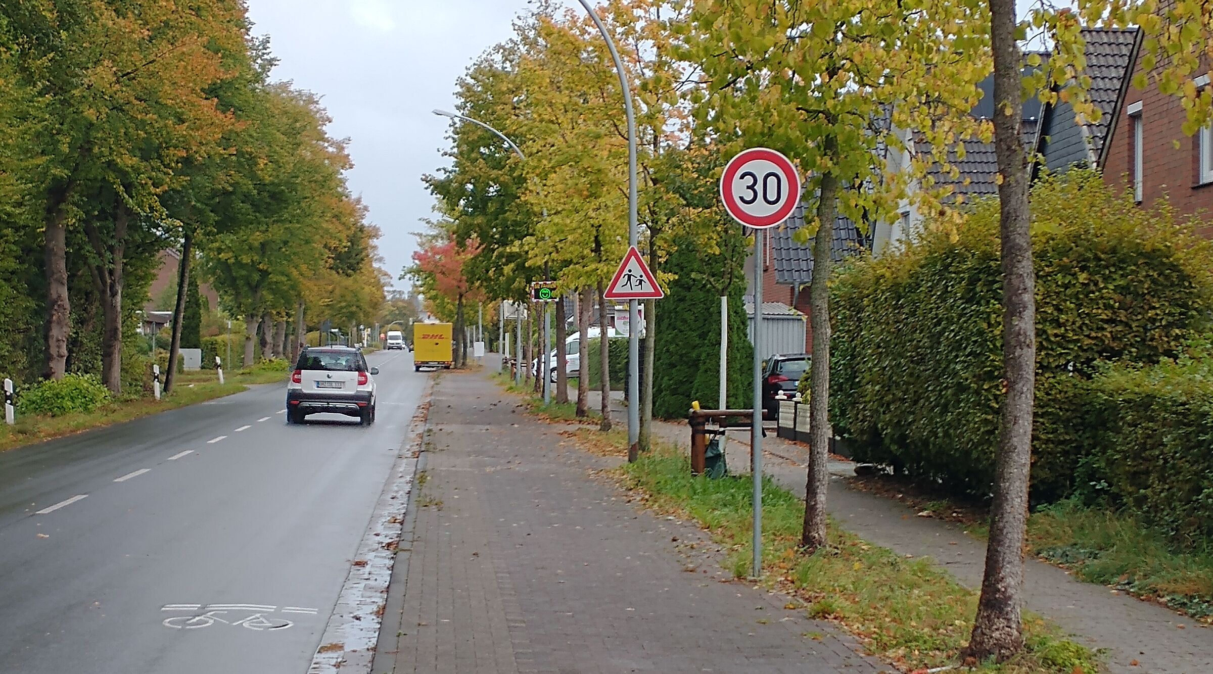 Tempo 30 mit grünem Smiley in der Ritterhuder Straße mit Fahradsymbol auf der Fahrbahn