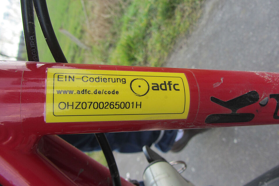 Kodierung Gezeigt wird der Aufkleber einer Klebekodierung mit der Kennung des ADFC-Osterholz an einem roten Fahrrad